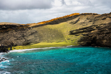 A coastal view of Green Sand Beach on the Big Island of Hawaii, known for its rare olive-colored...