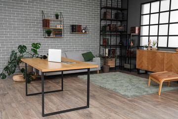 Interior of living room with workplace and bookshelves