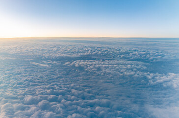 Beautiful orange and pink sunrise over the clouds, view from the plane.