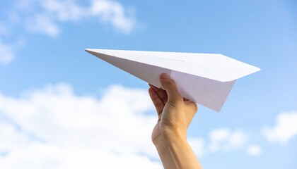 Close up photo of hand hold a white paper airplane with a blue sky background