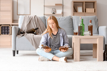 Young woman drinking alcohol at home. Concept of alcoholism