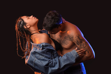 Young couple kissing on black background