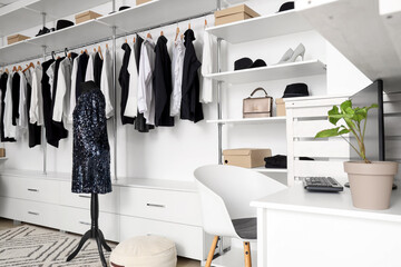 Interior of boutique with stylish clothes and table