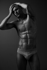 Black and white portrait of a muscular man, posing confidently while expressing strong emotions....