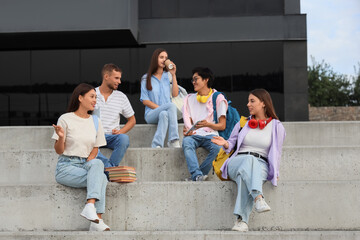 Group of young students sitting near university