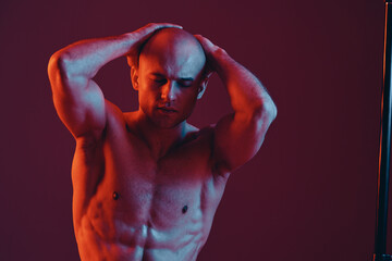 Muscular man with clenched fists and closed eyes, showcasing strength and determination in a...