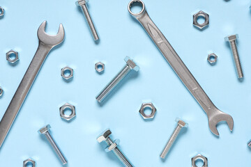 Tap bolts, chrome nuts and wrenches on blue background