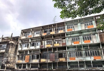 Grungy old residential building in a dense urban area of Bangkok