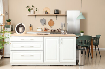 Interior of kitchen with counters, shelf and dining table