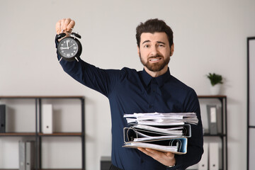 Stressed businessman with stack of papers and alarm clock trying to finish his job in time....