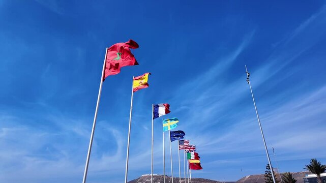 Morocco Spain France Sweden Europe nations flags USA Italy wave Agadir beach, clear blue sky