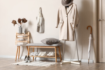 Bench with shoes stand and coat hanger in interior of hallway
