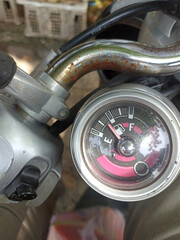 vintage model fuel gauge on a motorcycle that shows when the tank is almost empty