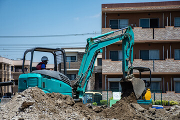 小型ショベルカーで住宅地の造成作業をする作業員
