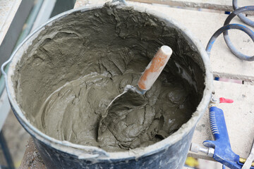 Bucket with cement mortar for exterior plastering of a house