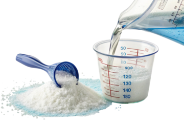 Laundry detergent powder being measured with scoop and jug isolated on transparent background