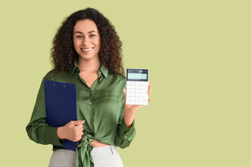 Young African-American woman with calculator and clipboard on green background