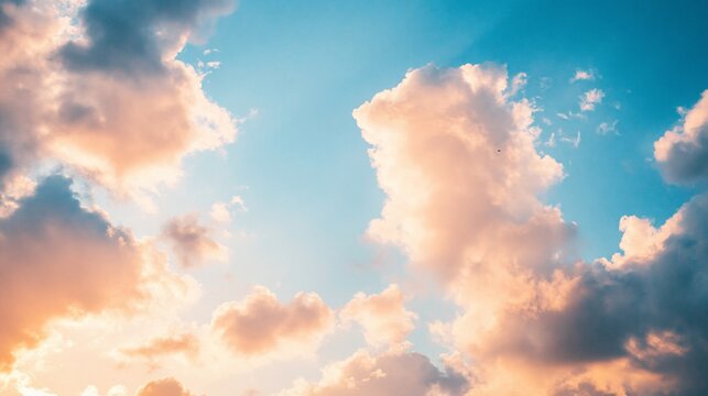 Azure sky scattered with puffy pink-tinged clouds catching sunlight - Powered by Adobe