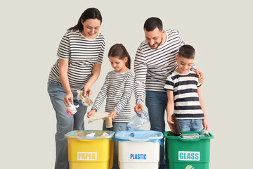 Family with containers sorting garbage near light wall. Global Recycling Day