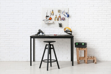 Interior of workshop with desk, peg board and working tools