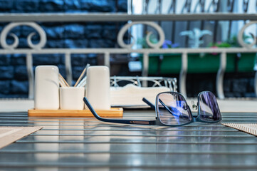 Eyeglasses lie on table in a street cafe.