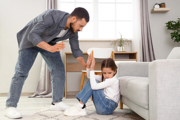 Father threatening his daughter at home. Domestic violence concept