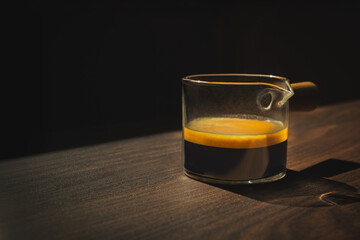 Espresso coffee in a glass cup on a dark background.