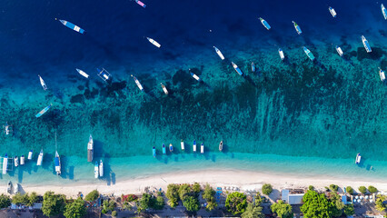vertical pan of boats off of the island of Gili Trawangan with a slight current curving the docked...