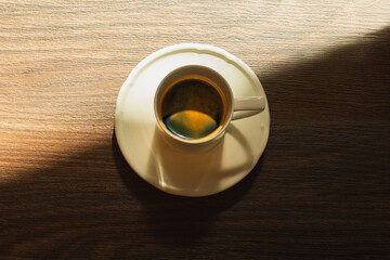 Espresso in a cup on a wooden table top view.