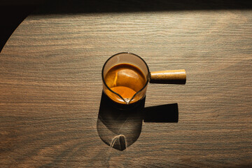 Top view of fresh espresso coffee in a glass on wooden table.