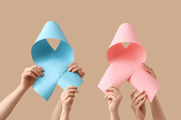 Many hands with different ribbons on beige background. Cancer awareness concept
