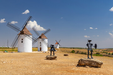 Traditional windmills and don quixote statue standing in Mota del Cuervo, Spain
