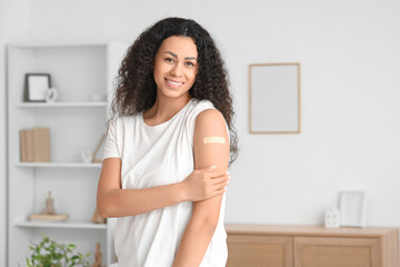 Young African-American woman with medical patch after vaccination at home