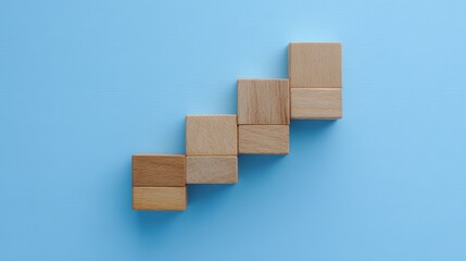 Wooden blocks in staircase formation on blue, minimalist composition symbolizing growth and progress

