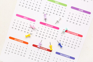 Calendar with paper pins on light background