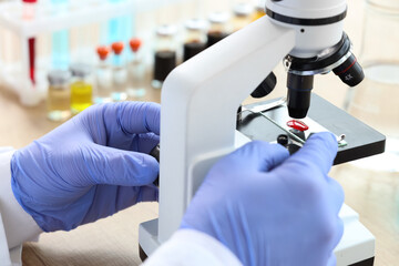 Male scientist with microscope working in laboratory, closeup