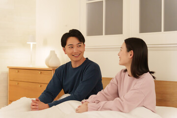夜ベッドで会話する夫婦
