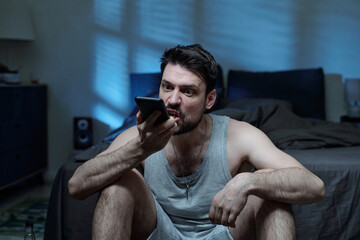 Caucasian young adult man holding smartphone shouting at it with frustrated facial expression...