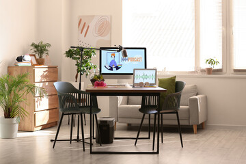 Interior of light studio with podcaster's workplace and plants