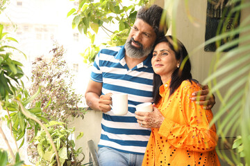 Indian happy couple drinking coffee in balcony. Happy morning together. Happy moment, harmonic...