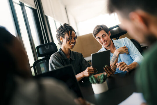 Cheerful diverse coworkers having fun during work break using technology enjoying working together - Powered by Adobe