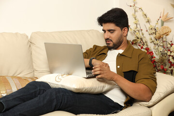 Indian young man working on laptop under work pressure office work stress at home. Stress and headache while working remote on laptop from home. pressure from workload or a deadline and tired.