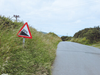 20% gradient warning road sign by the side of a country road