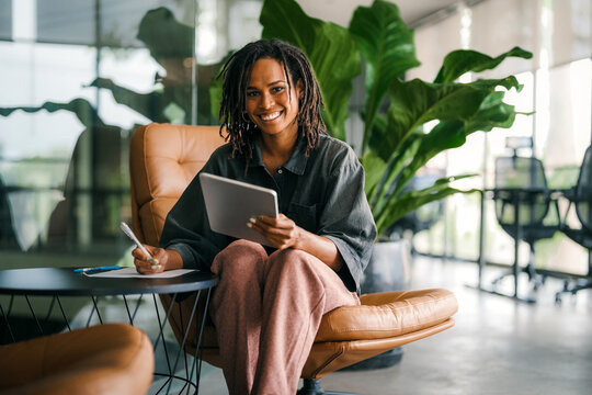Smiling black successful business woman, freelancer, coworker female leader using digital device - Powered by Adobe