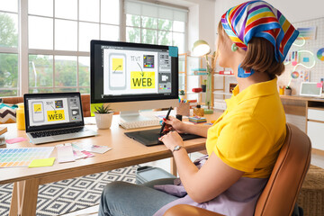 Beautiful web designer working with graphic tablet at table in office