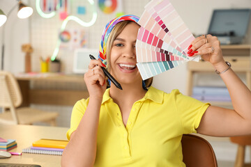 Beautiful web designer with color palettes in office