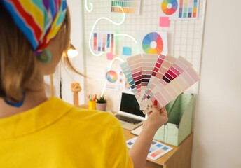 Female web designer with color palettes in office, closeup
