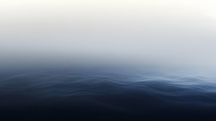 Deep blue ocean surface with gentle waves and soft misty sky, creating a serene seascape