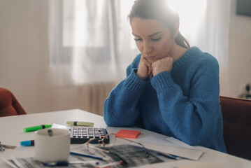 Stressed woman managing home finances and calculating bills at home office