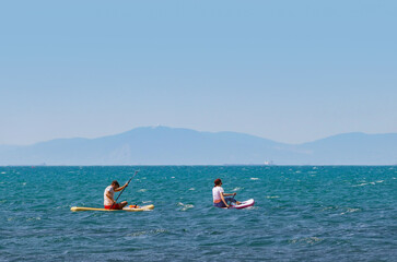 young couple   riding  on sup surfing in the sea at sumer time